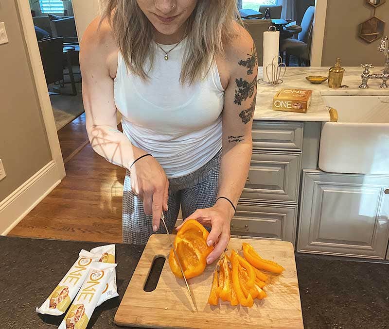Finley cutting orange peppers